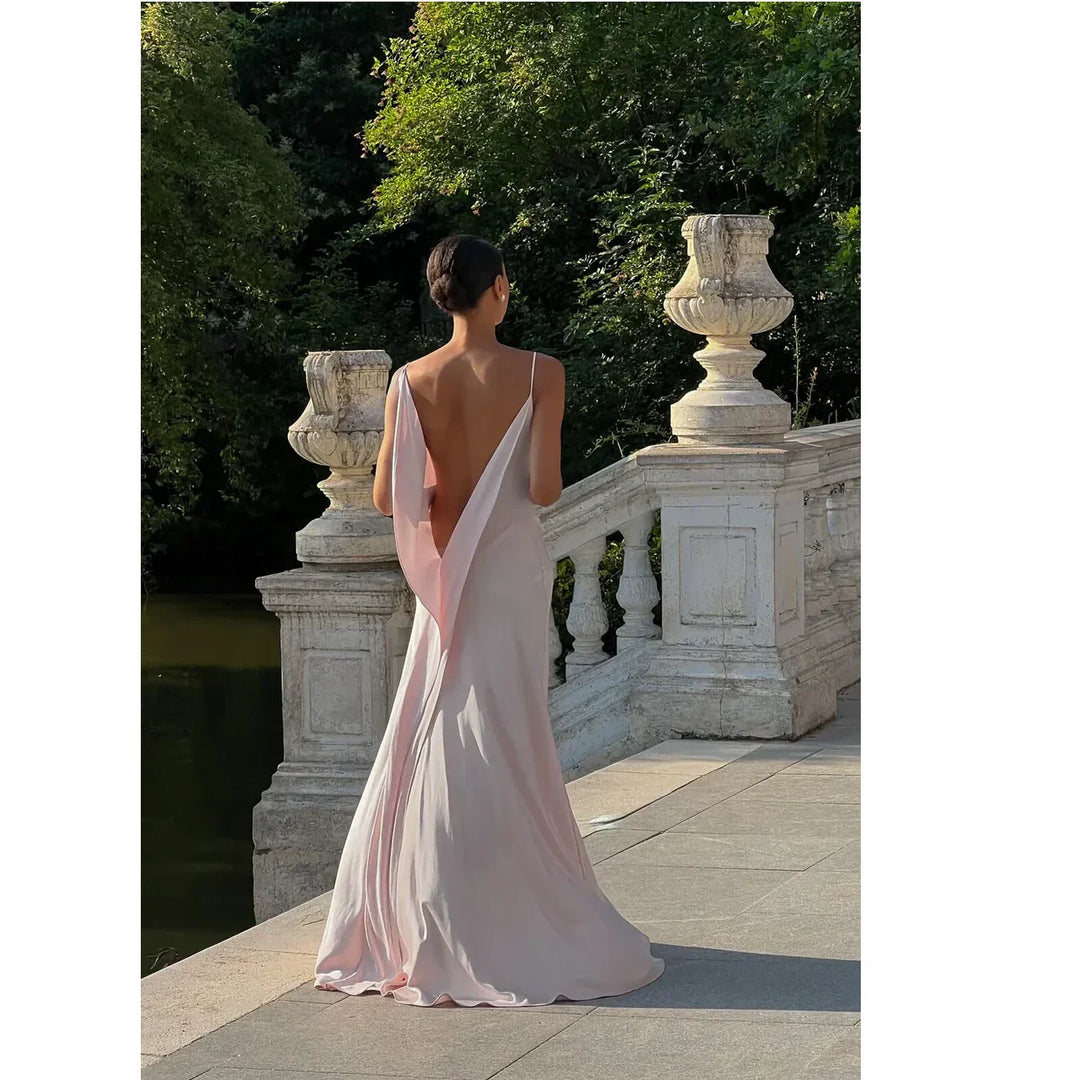Elegant woman in pale pink backless dress on stone terrace, Rovelli fashion photography