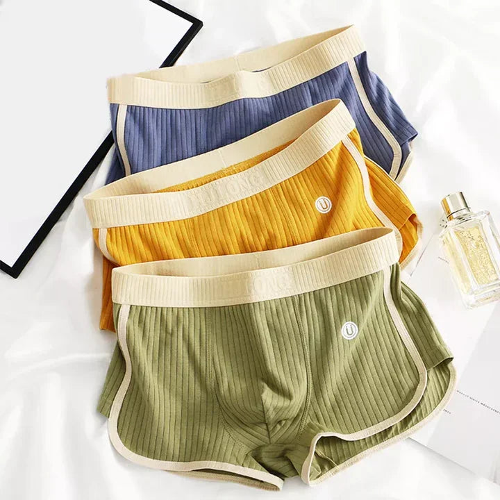 Rovelli ribbed cotton boxer shorts in blue, yellow, and green laid on white fabric