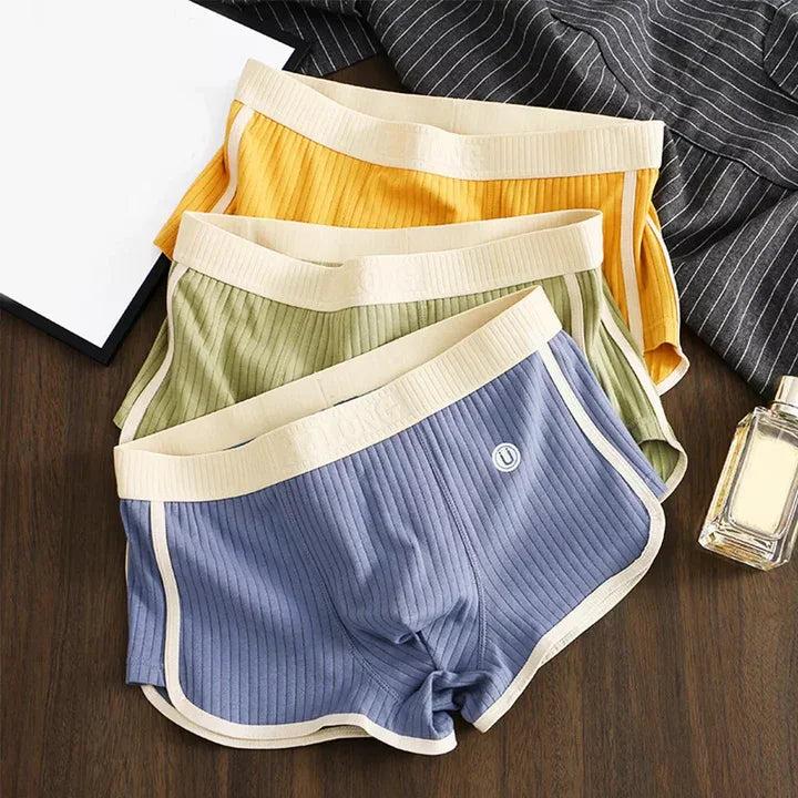 Rovelli ribbed cotton lounge shorts in yellow, green, and blue on wooden table