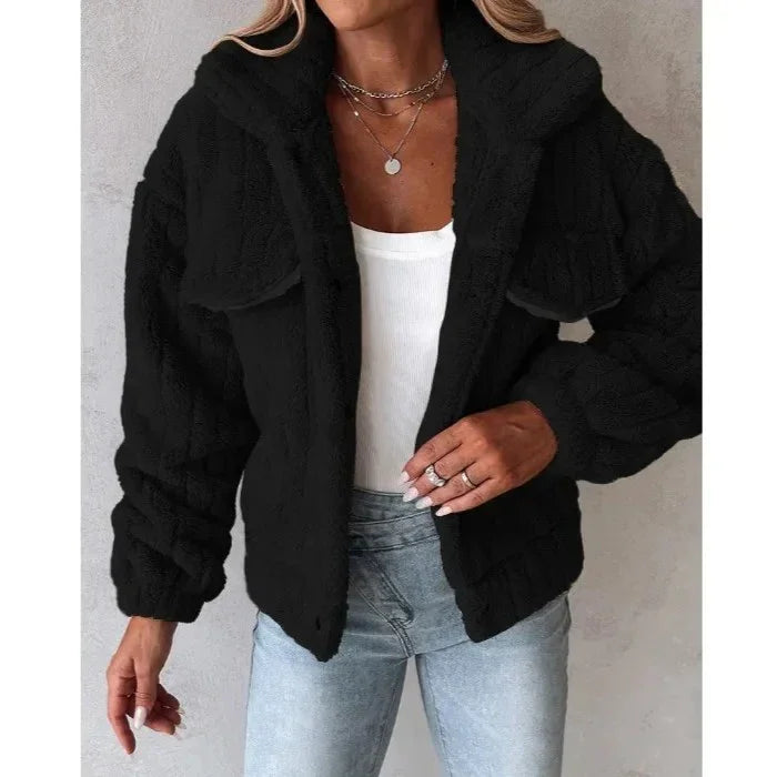 Woman wearing black faux fur jacket, white top, light blue jeans, Rovelli fashion