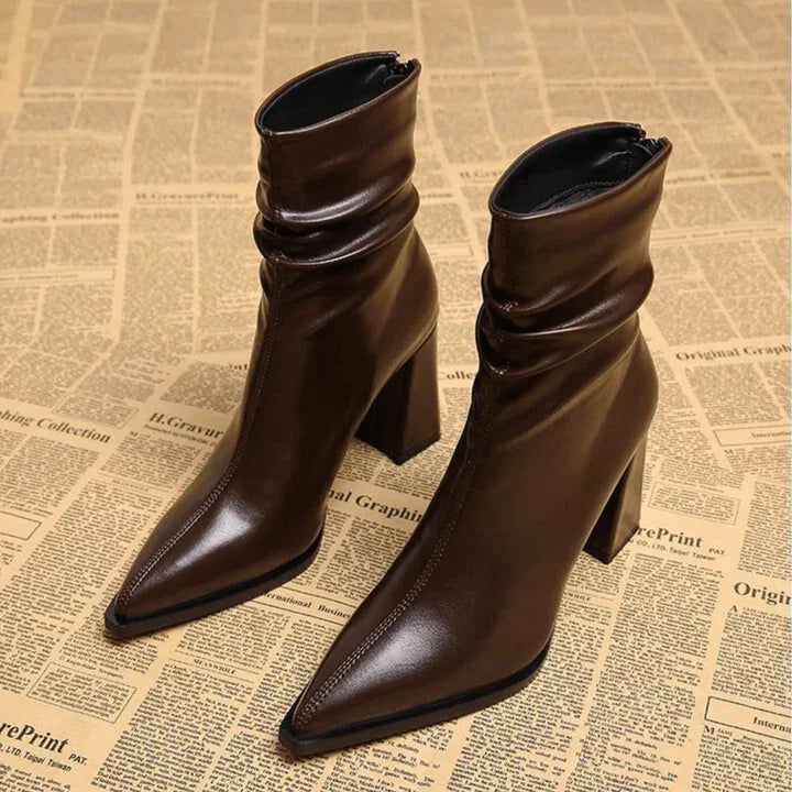 Brown pointed-toe leather heeled boots on vintage newspaper, Rovelli fashion footwear