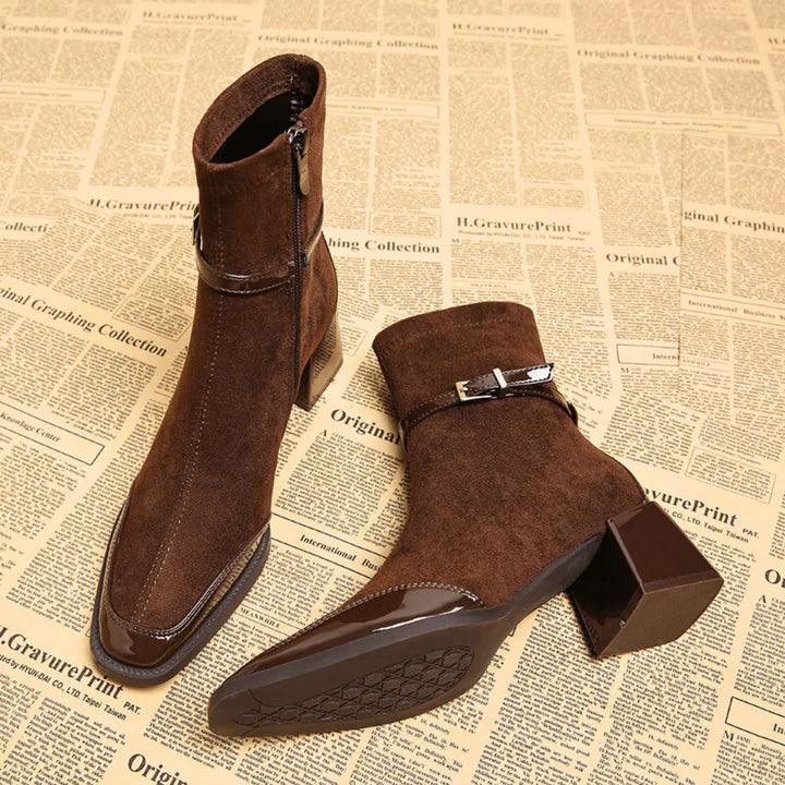 Brown suede ankle boots with side zippers and block heels on vintage newspaper background, Rovelli