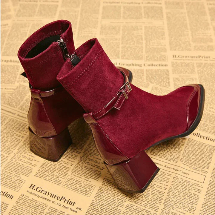 Red suede and patent leather ankle boots with chunky heels on vintage newspaper, Rovelli