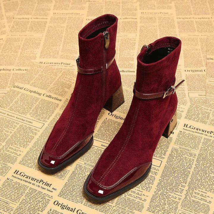 Rovelli burgundy suede heeled boots with side zip and buckle on vintage newspaper background