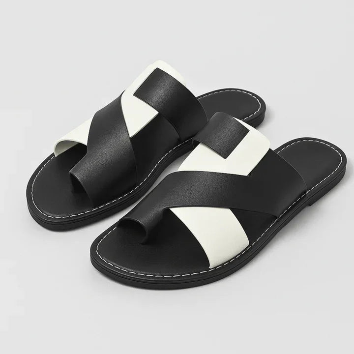 Rovelli black and white crisscross leather slide sandals with stitched soles on light background