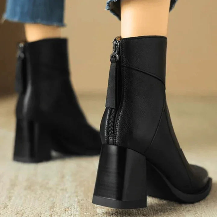 Rovelli black heeled ankle boots with side zipper, worn with blue jeans on beige carpet