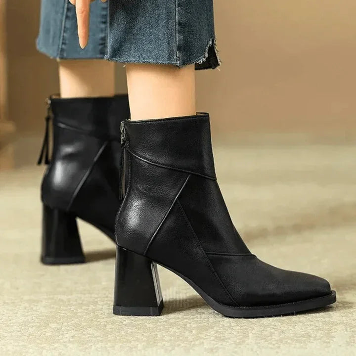 Rovelli black leather heeled ankle boots with zipper, worn with cropped jeans on carpet