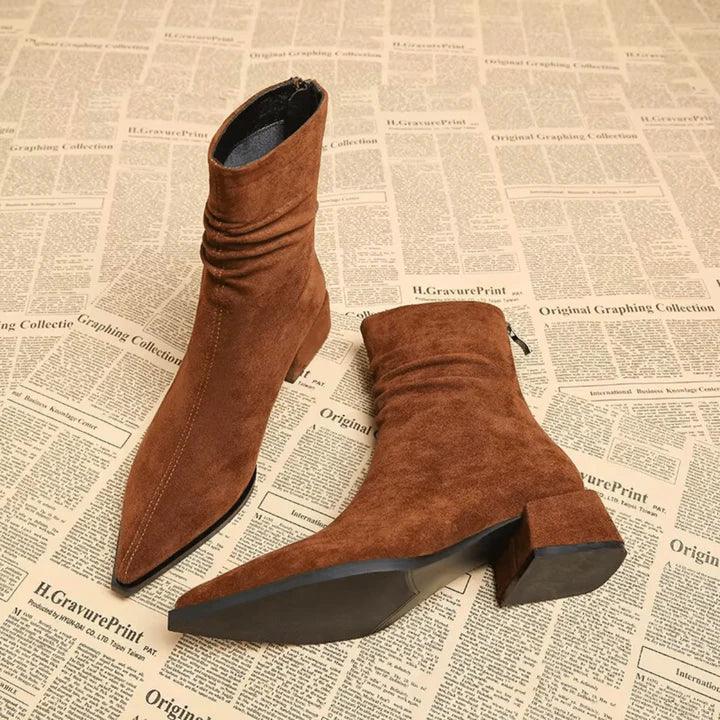 Rovelli brown suede pointed-toe ankle boots with block heel on newspaper background